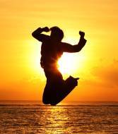 Woman jumping in front of sunset
